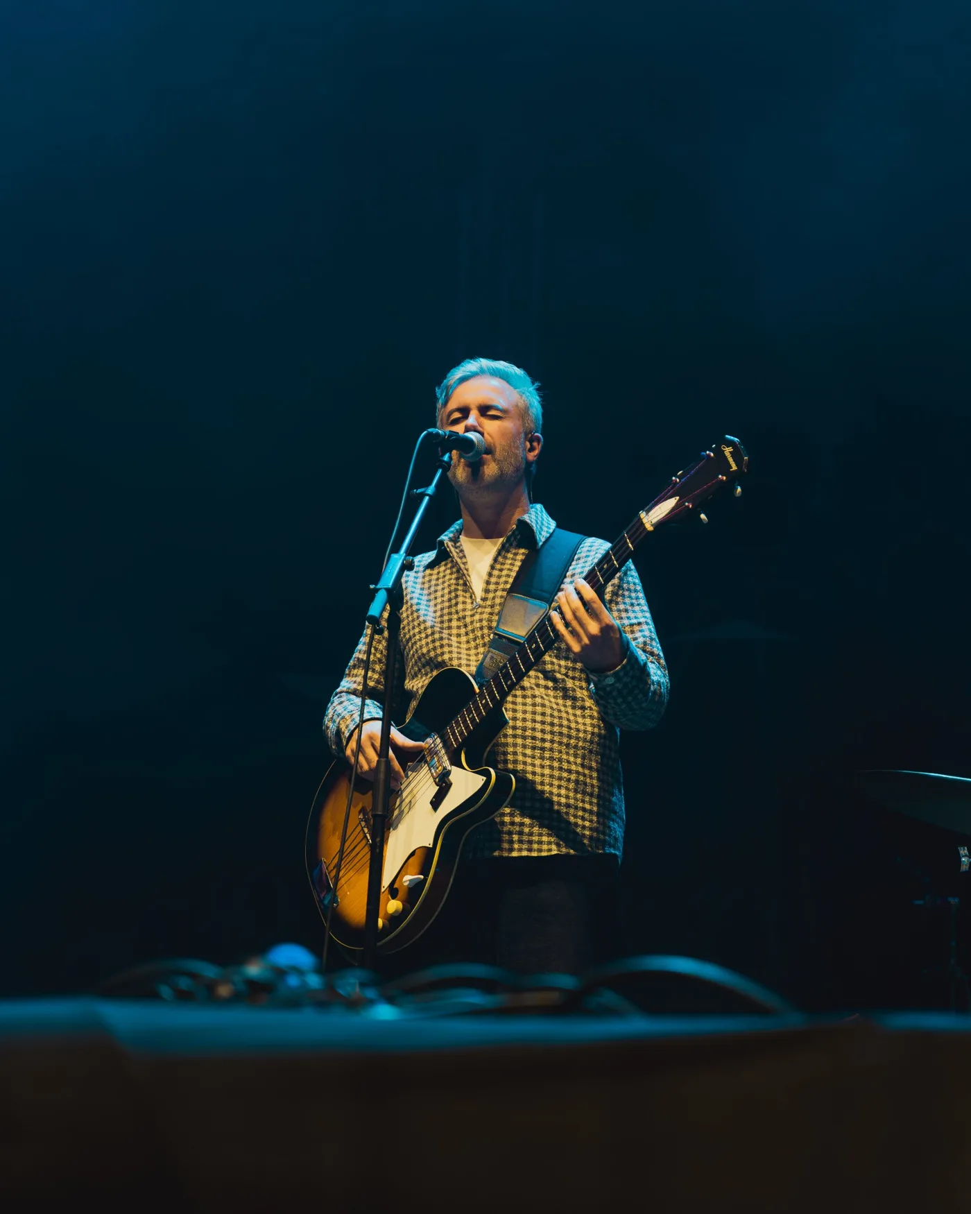 Euan Burton singing and playing bass on stage